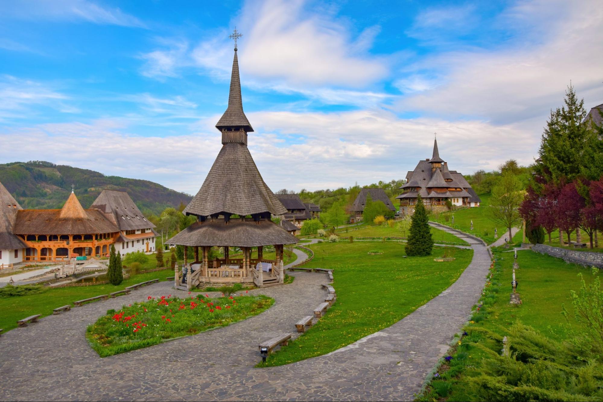 Traditional Maramures wooden architecture of Barsana monastery, Romania at sunny spring day. Picturesque sky