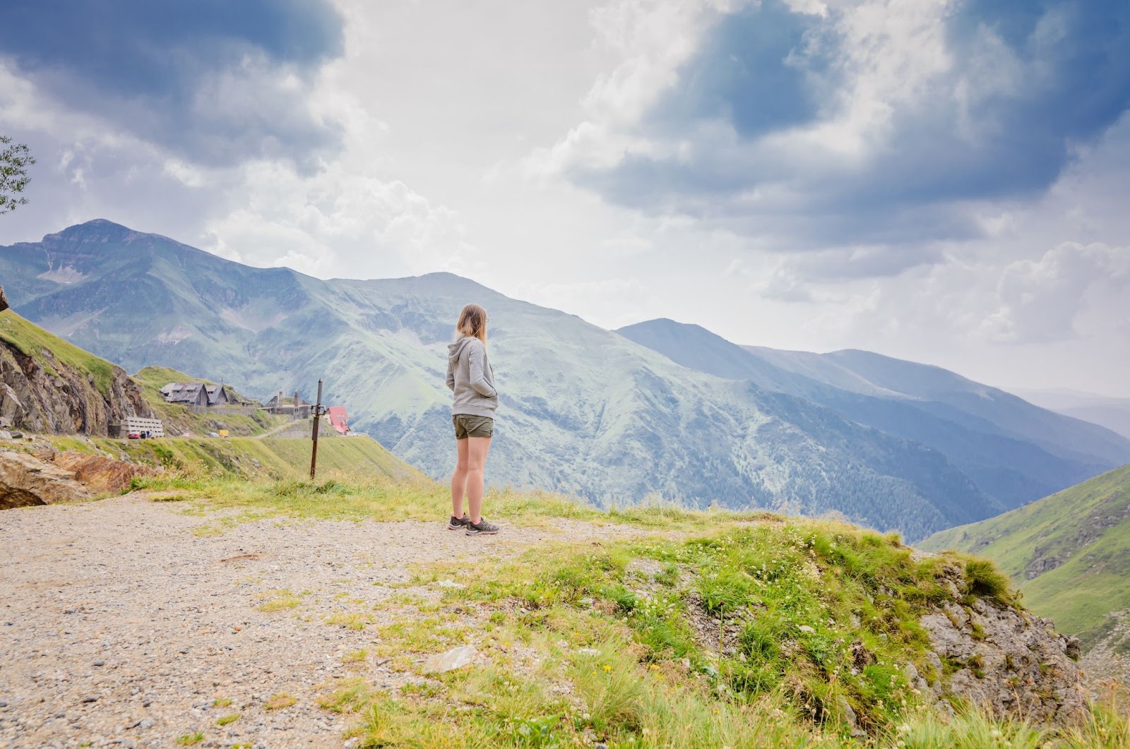 Young woman on cliff's edge in Romanian Carpathian mountains near Transfagarasan Road